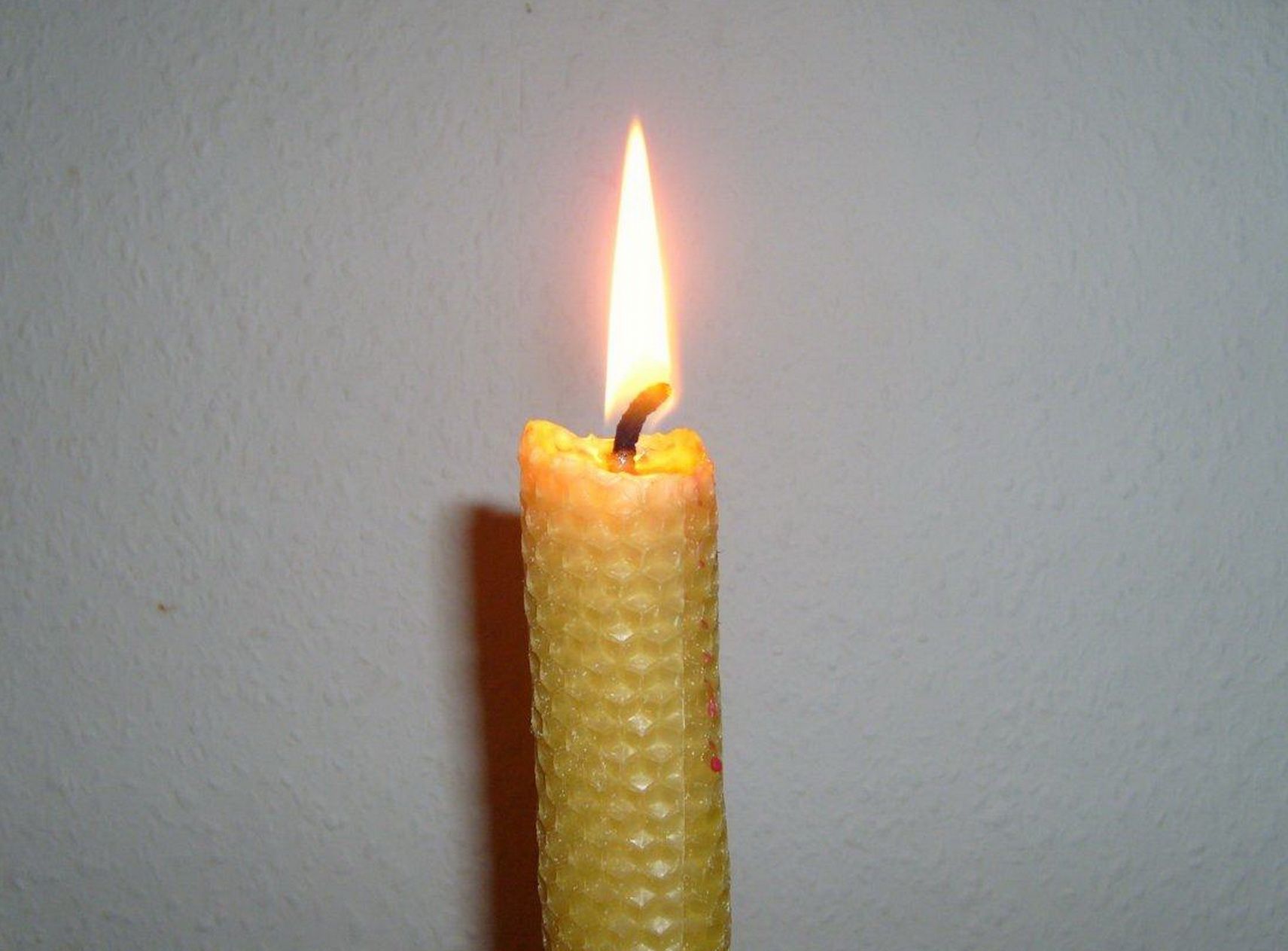 A lit rolled beeswax candle